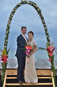 The lovely bride and groom underneath the wedding arch overlooking the Caribbean Sea.