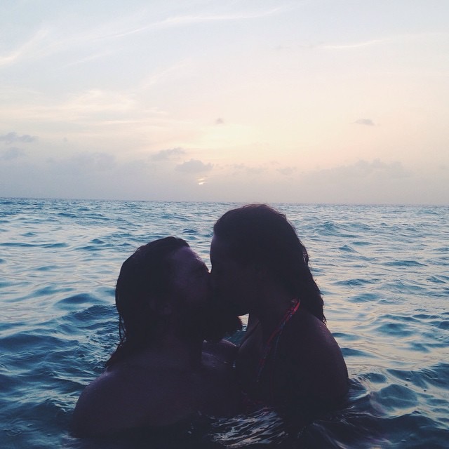 Couple swimming in the Caribbean Sea at Coco Plum Island Resort Belize. Enjoy a romantic vacation on a secluded private island for adults only