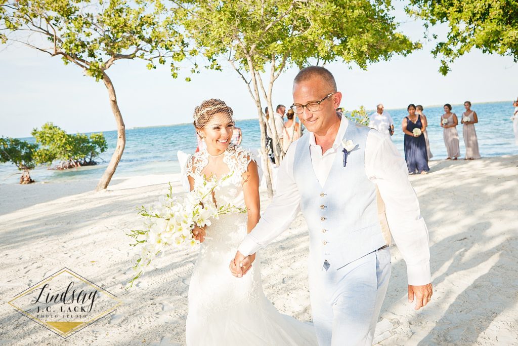 David and Ashley newlyweds holding hands during their wedding ceremony