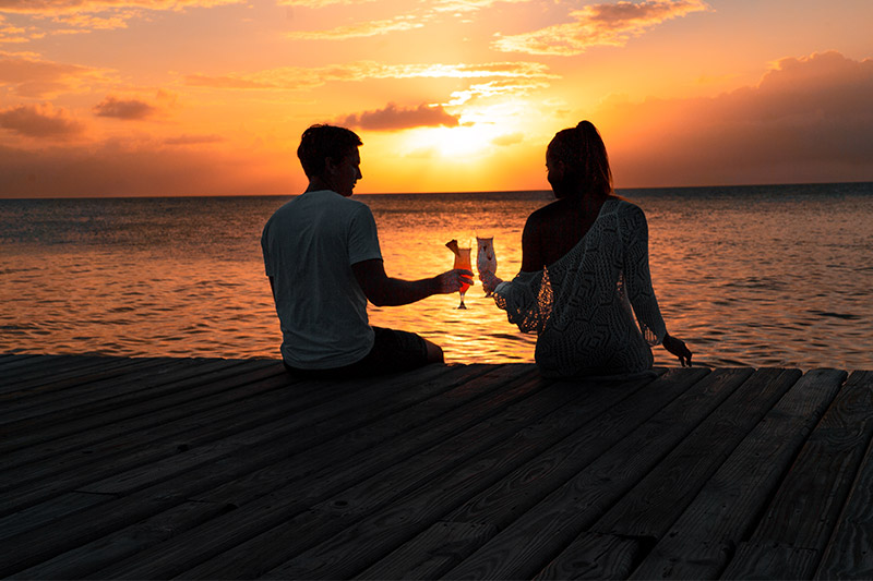 Evening image of a couple enjoying a drink at Coco Plum Island - one of the best all inclusive adults only resorts in Belize